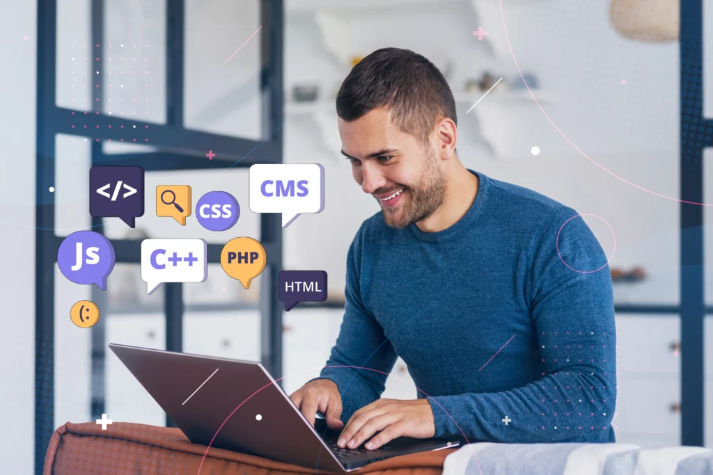 A web designer in Michigan sits typing on a laptop, surrounded by floating programming language icons like JS, C++, PHP, and CSS.